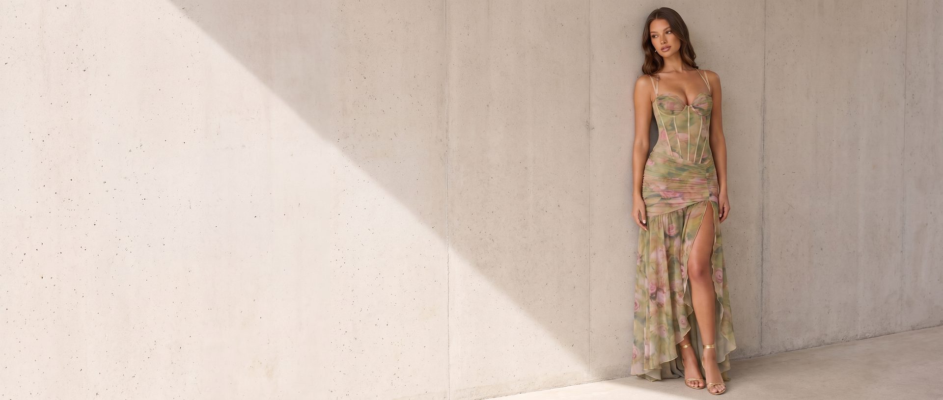 Woman in a sage-green floral midi dress against a modern concrete wall - Summer in Marettimo